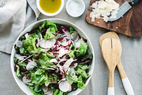 Radish and lettuce salad with chopping board, olive oil,, salt and utensils