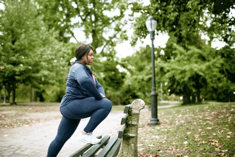 black woman stretching on a bench for her exercise