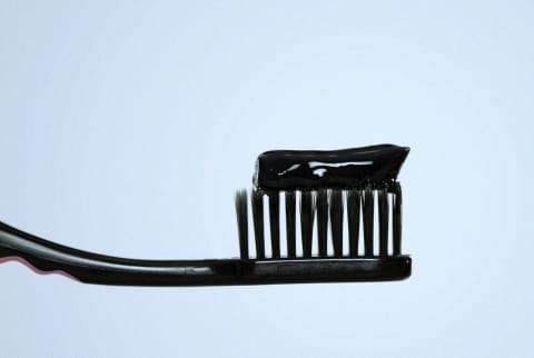 Charcoal toothpaste on a toothbrush