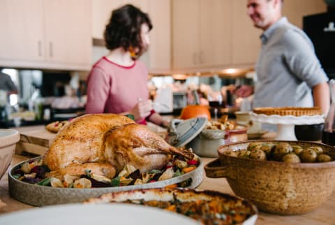 Thanksgiving cooking in the kitchen with turkey, potatoes, and other sides