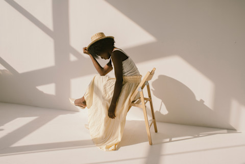 Young woman sitting down in a white room Young woman sitting down in a white room