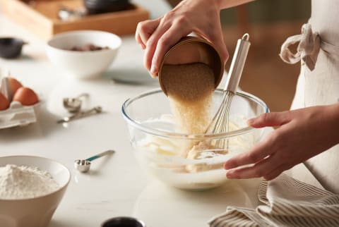 Brown sugar being poured into dough