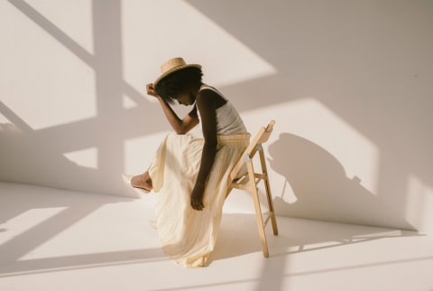 Young woman sitting down in a white room