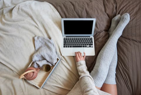 person with a computer in bed