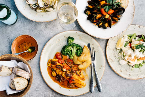 Branzino dish with mussels, clams, and vegetables