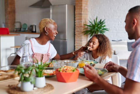 family eating nutritious meal together at dinner table