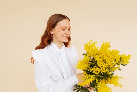 Young woman holding a bunch of yellow flowers
