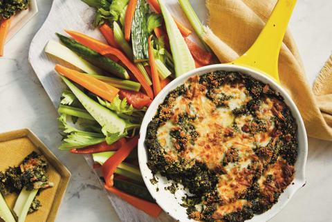 yellow cast iron skillet with spinach dip and crudite 