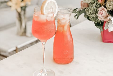 aperol spritz on a white counter with flowers