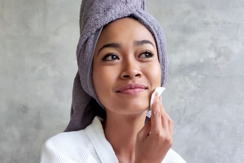 Woman wiping her face during a waterless beauty routine