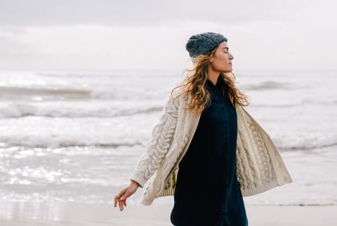 Woman on the Beach in Wintertime Soaking in the Moment