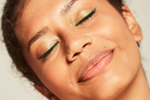 glowing skin with green eyeliner 