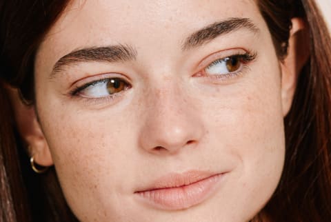 Smiling Young Woman with Freckles Looking Off Camera