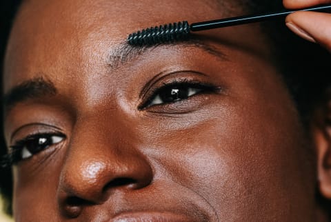 Woman Applying Castor Oil to Eyebrows