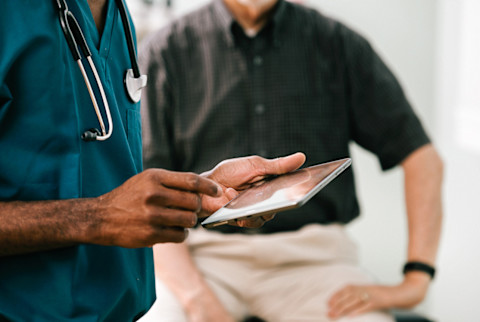 Doctor Enters Information Into Digital Tablet Doctor Enters Information Into Digital Tablet