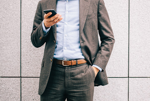Casual Business Man Looking At His Phone With His Hand In His Pocket Casual Business Man Looking At His Phone With His Hand In His Pocket