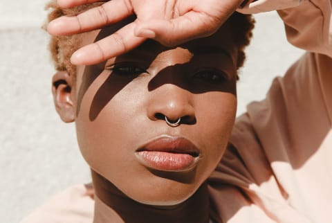 Young black woman blocks eyes from the sun
