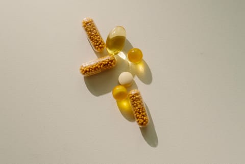 A handfull of supplements on a neutral background