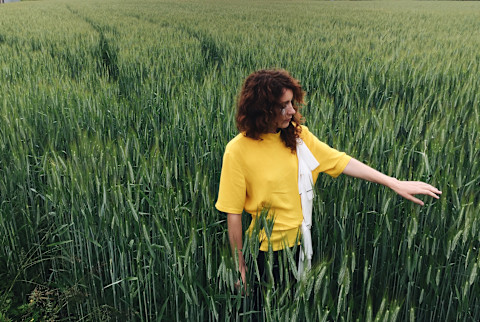 Lonely single woman in a field of tall grass Lonely single woman in a field of tall grass
