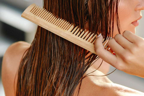 Woman Combing Her Wet Hair with a Wide Tooth Comb