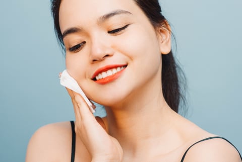 Young Woman Smile And Using Tissue With Toner For Cleaning Make Up
