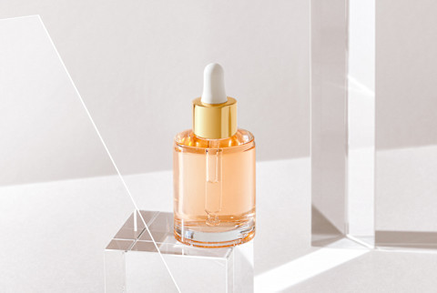 Clear Beauty Bottle with Dropper on a Glass Cube in Studio Clear Beauty Bottle with Dropper on a Glass Cube in Studio