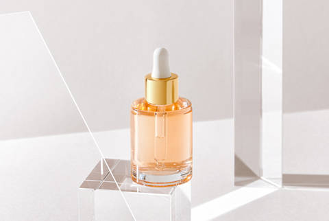 Clear Beauty Bottle with Dropper on a Glass Cube in Studio Clear Beauty Bottle with Dropper on a Glass Cube in Studio