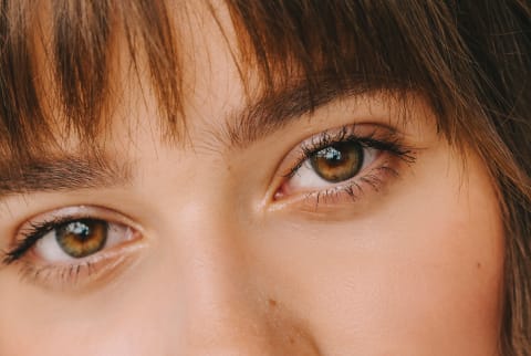 Closeup Beauty Shot of a Young Woman With Bangs And Full Brows
