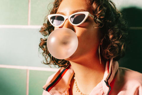 Teenager In Retro Tracksuit Blowing Bubblegum