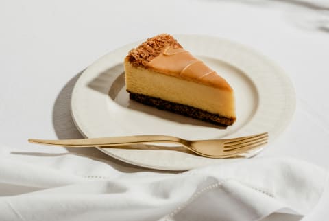Caramel cheesecake on a plate in a minimal setting