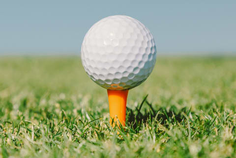Golf Ball In An Orange Tee