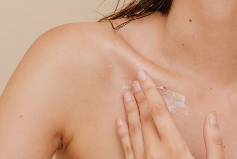 Woman Applying Sunscreen On Collarbone