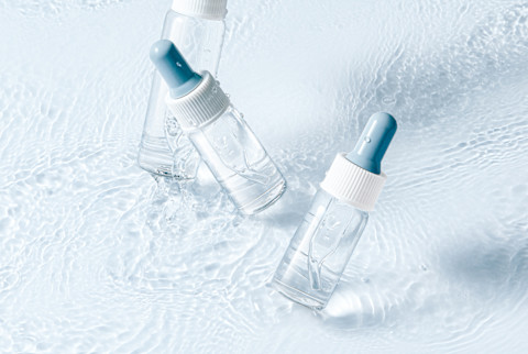 Clear Bottles of Serum on a Blue Background Clear Bottles of Serum on a Blue Background