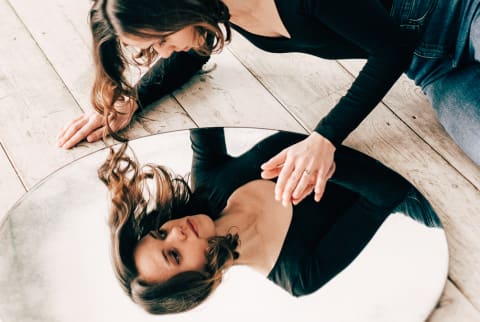 Woman Lying On Floor With Round Mirror