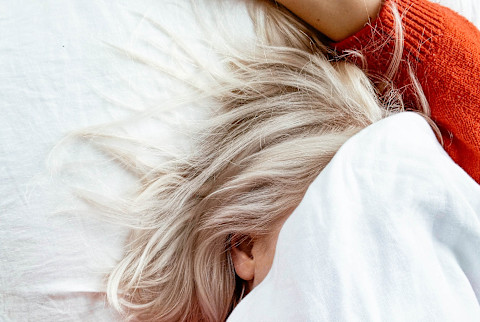 Young Woman in bed under the covers Young Woman in bed under the covers