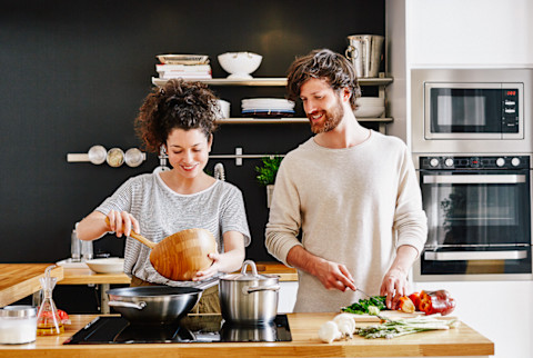 Happy young couple cooking together in kitchen