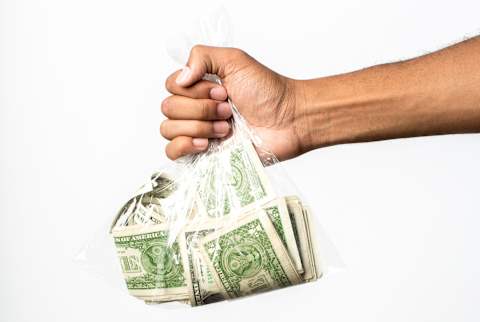 hand holding a bag of money hand holding a bag of money