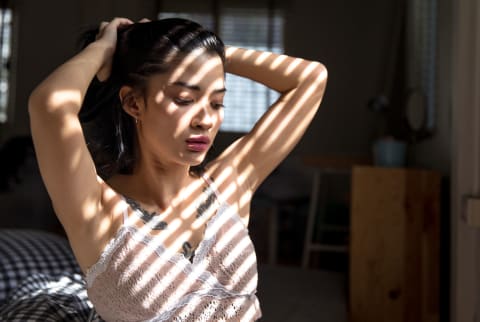 Woman without enough sleep in front of a window