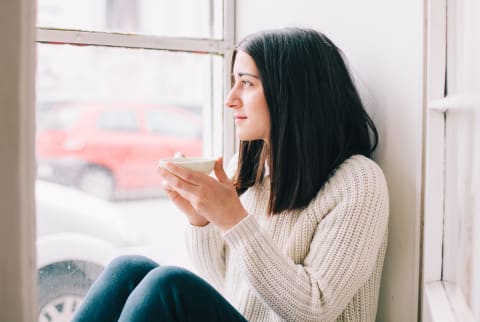 Brunette Woman Drinking Tea Sitting Near A Window