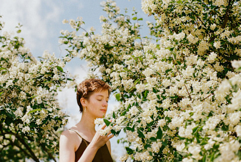 Portrait Of Young Woman Enjoys Spring Blossom