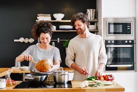 Happy young couple cooking together in kitchen