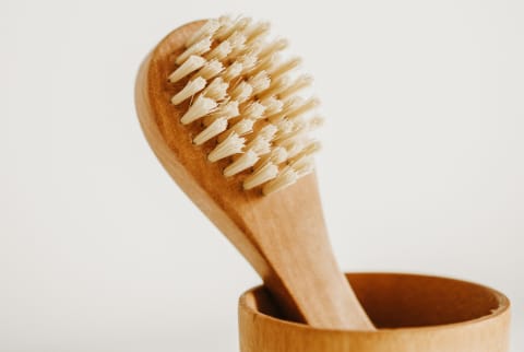 dry face brush in a holder on a white background