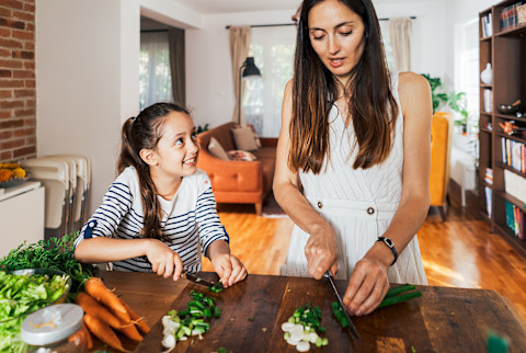 mother and daughter cutting vegetables mother and daughter cutting vegetables