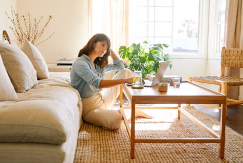 Woman sitting in her living room working on a laptop