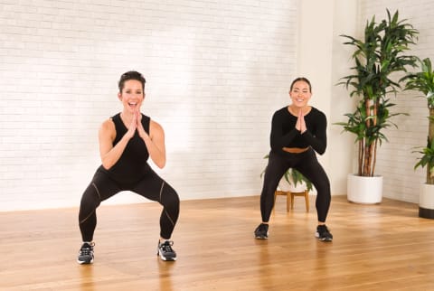 two women doing squating exercise