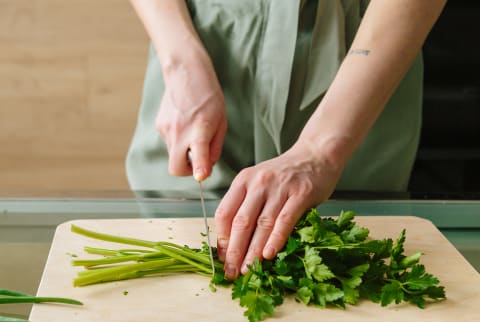 Unrecognizable Woman Cutting Off Parsley Stems