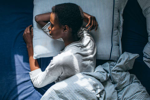 Overhead photo of a woman sleeping with her arm under her head