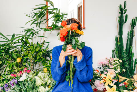 Florist Holding a Bouquet of Flowers In Front Of Her Face