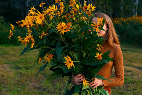 Young woman carrying a large bouquet of flowers