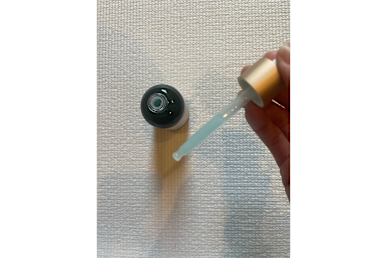Biossance Squalane + Copper Peptide Rapid Plumping Serum bottle is open, with some product being dispensed using the applicator
